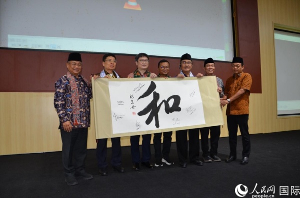 嘉宾在“和”字卷轴上签名留念 人民网记者 李培松摄