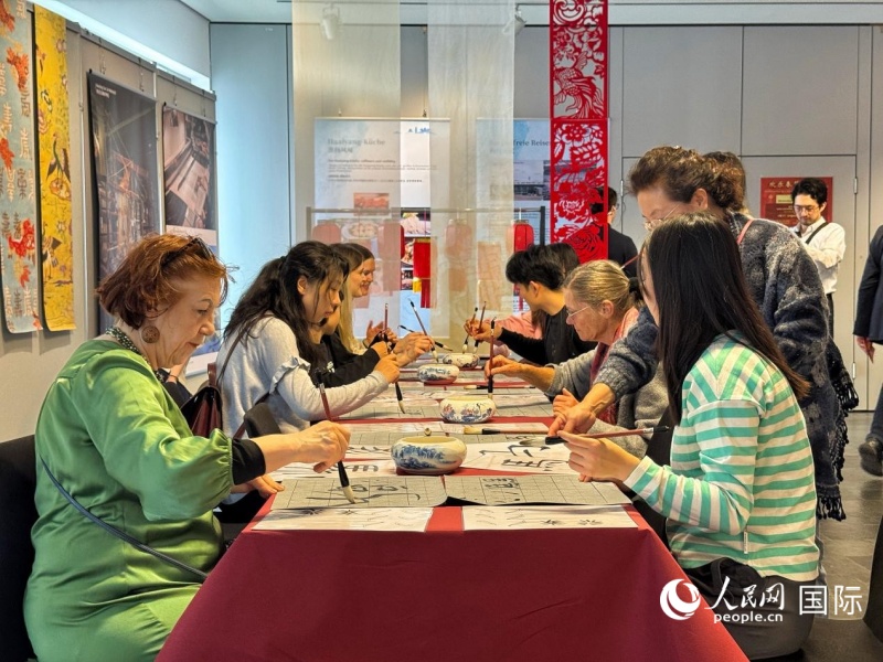 来宾们在练习书法,感受汉字书法之美。人民网实习生 赵宏笙摄