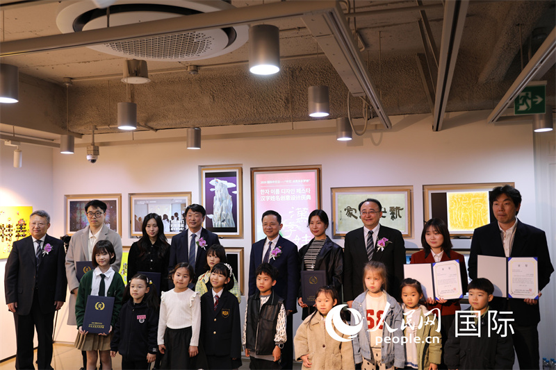 2. 出席活动的嘉宾与“汉字姓名创意设计”获奖者合影。人民网记者 莽九晨摄